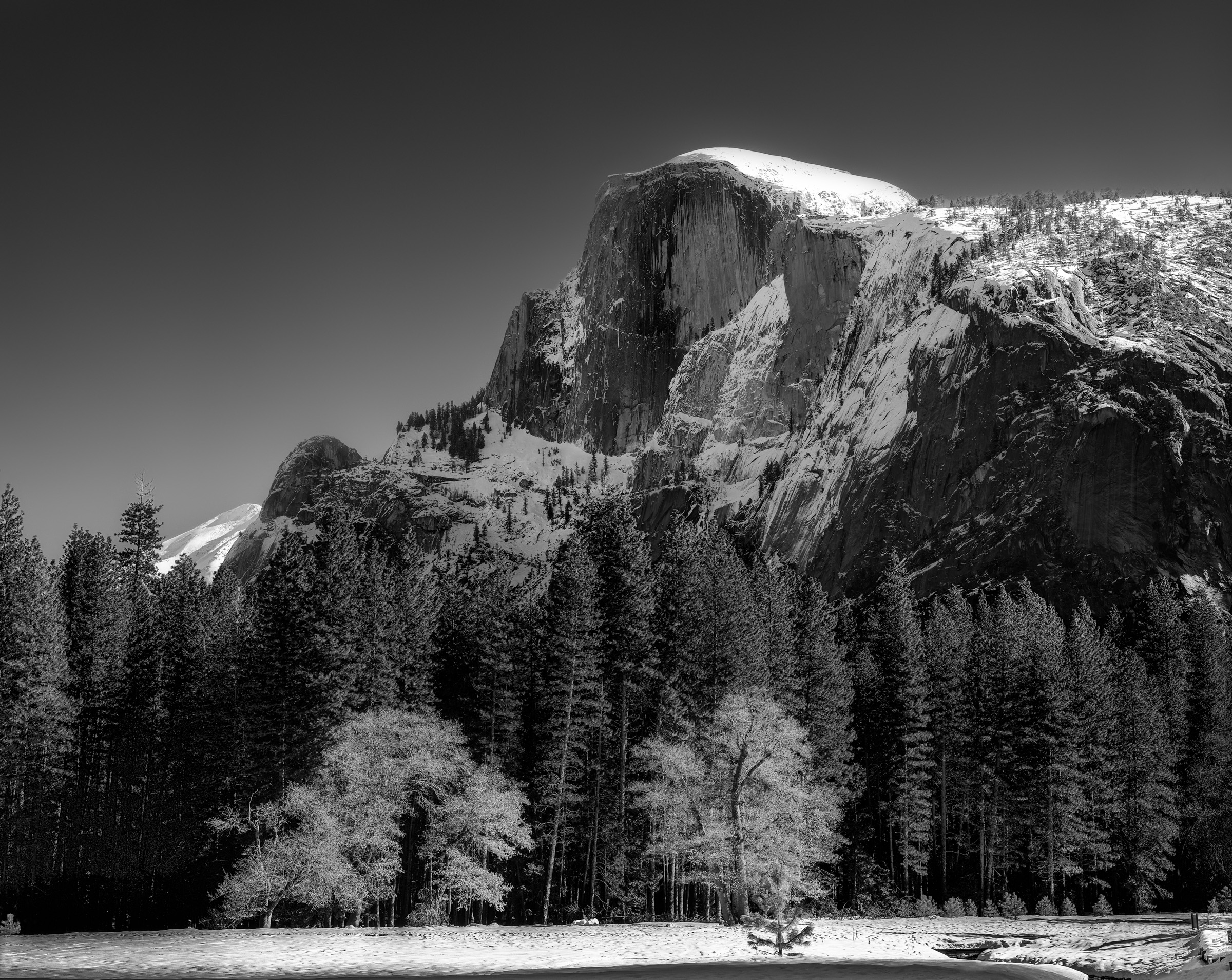 Half Dome in winter, black and white, dramatic light on the granite face